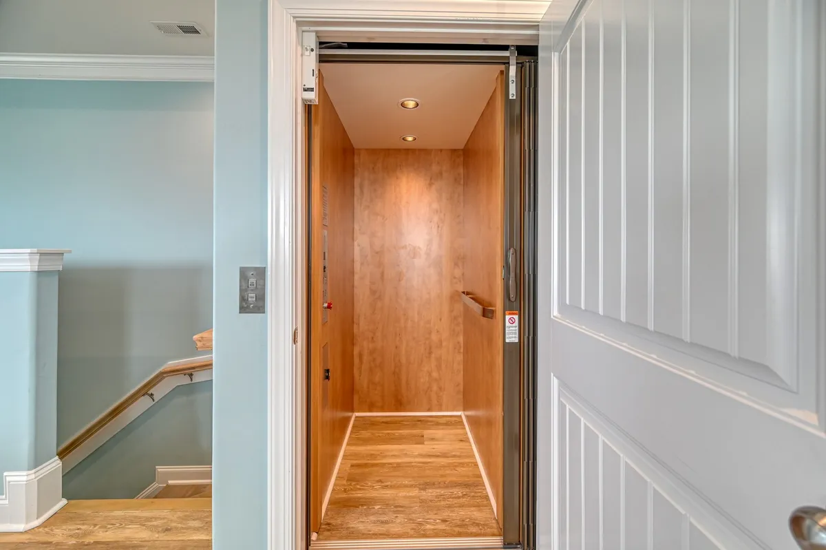 This interior image features the elevator's wood-paneled interior with warm lighting, conveying accessibility and comfort for moving between floors with luggage or groceries.